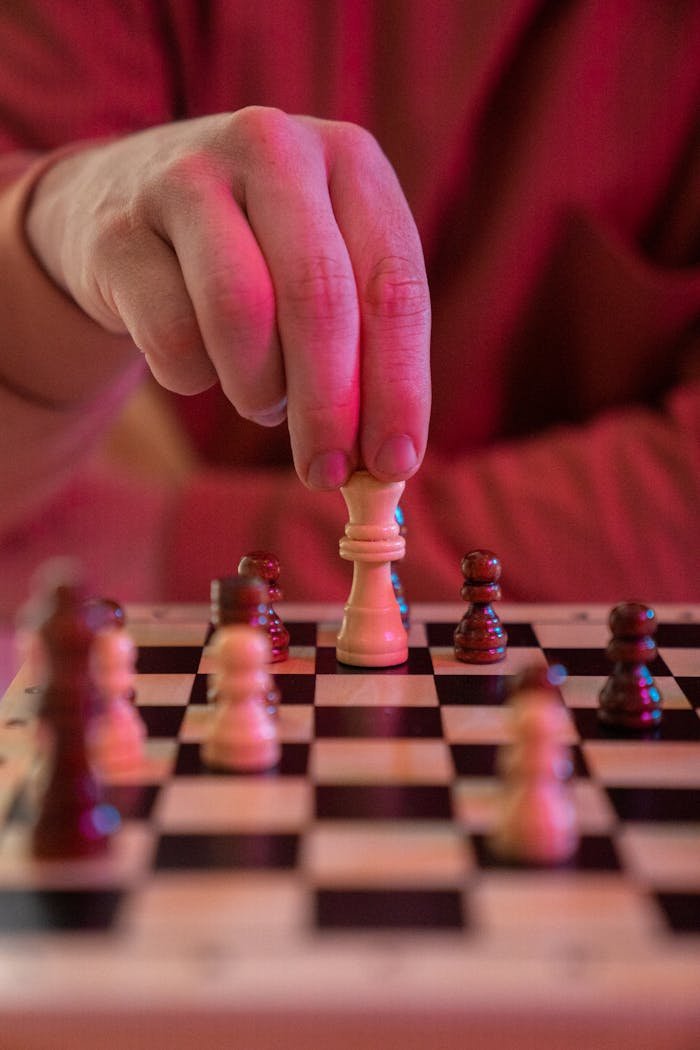 about-us-02 Close-up of a hand moving a chess piece, symbolizing strategy and focus.