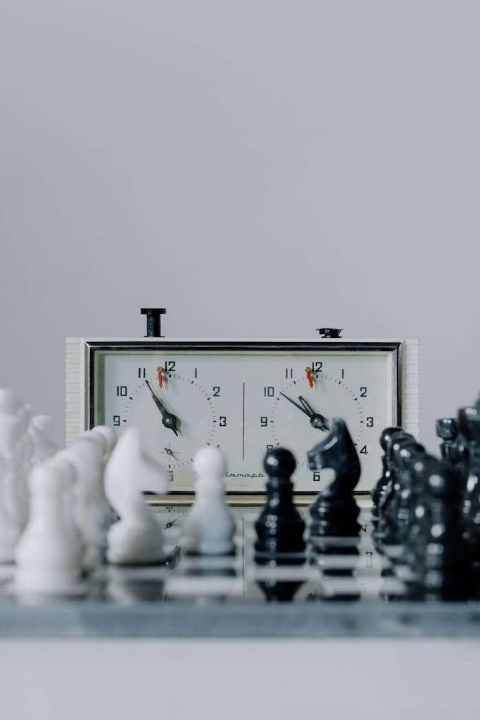 heros-img Chessboard setup featuring a classic chess clock with white and black pieces ready for play.
